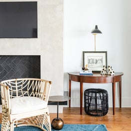 Design detail of custom fireplace and antique demi lune tables 