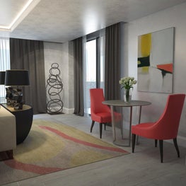 Red accent chairs give the neutral room a pop of color.