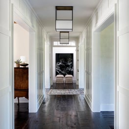 Hamptons Residence Entry Hall with paneled walls and dark wood floors.
