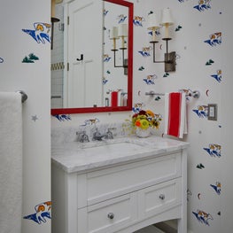 Three Barn Farm Bathroom. Playful cow print wallpaper, red framed mirror & accent sconce.