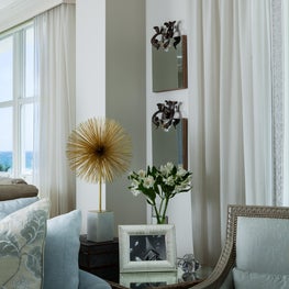 Pale blue fabrics blend well with the ocean views in this transitional room.