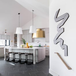 A brass Monogram vent hood commands attention in this beautiful renovated kitchen.