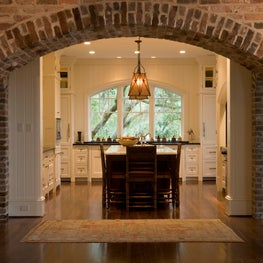 Brick Hallway Arch with White Kitchen, Island and Segmental Arch Window