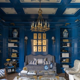 Rich blue-lacquered study with unexpected pops of gold and brass accessories