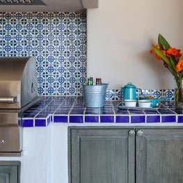 Bold colors blend into the surroundings in this seaside outdoor kitchen.