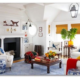 This transitional white living room has pops of blue and ample natural light.