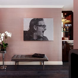 Manhattan foyer with pink grasscloth wallpaper, dark wood floors and graphic art