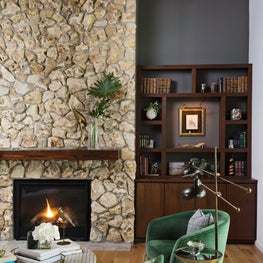 Stone fireplace in this renovated rustic home in horse country