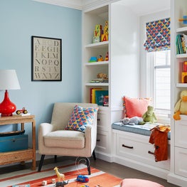 Blue nursery with window seats and built-ins and striped rug