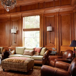 In this library, decorative wood paneled walls create a warm luxurious ambiance.