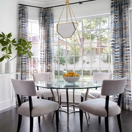 The sunroom beyond the home bar is multi-functional serving as a cozy spot to enjoy breakfast or enjoy an evening of fun and games with guests!