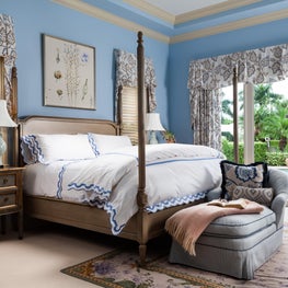 The four poster bed provides a feminine mystique with a pastel blue backdrop.
