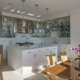 Polished stainless steel upper cabinets in a modern beach house kitchen