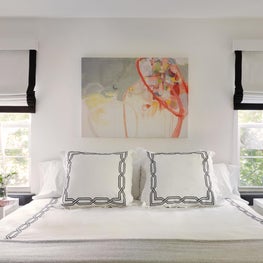 Hamptons Bedroom with black and white shades, gold lamps, art and crisp bedding
