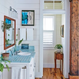 White Shiplap walls, heart of pine flooring and pastel subway tile.