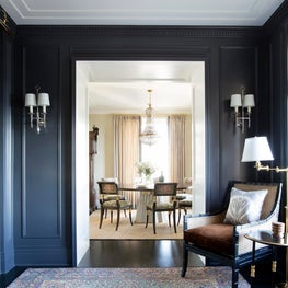 Traditional sitting room with dark walls, white sconces