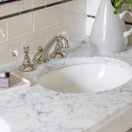 marble top on polished nickel washstand with subway tile