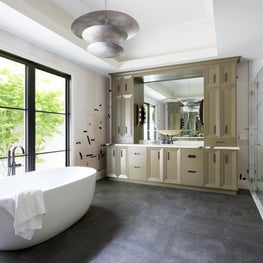 Portfolio: The master bathroom at Pebble Beach, CA with geometric wall covering and white soaking tub.