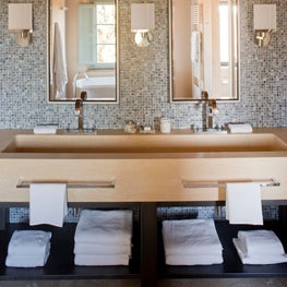 Mosaics set the stage for the double vanity with open shelving