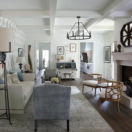 Serenbe Family Room with cast stone fireplace & bold wallpaper