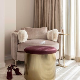 Portfolio: Feminine and neutral-toned sitting area in the corner of The River Oak's master bedroom