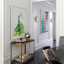 Gold and black console table, white wainscoting in breakfast room