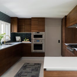 Portfolio: Dark wood cabinets and blue tile backdrop in a Poggenpohl kitchen