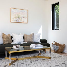 Dark blue couch and acrylic and contemporary brass and glass coffee table