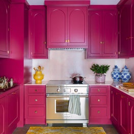 Custom Kitchen Cabinets in berry with arch detail, pink marble, & brass fixtures