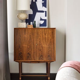 Artful living room with mid-century lamp and bar cabinet and custom silk carpet.