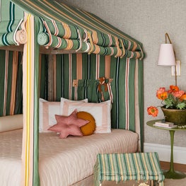Colorful childrens room with striped tented bed and mid century green bedside table