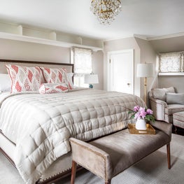 Brass & crystal chandelier in neutral bedroom w modern bench, zebra chair, lamp