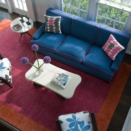 Colorful Hamptons country house living room, patterned chairs and pillows 