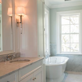 Carrara Marble Bathroom with Freestanding Tub, Tile Wainscoting and Window