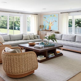 Relaxing Hamptons living room with rattan chairs and colorful art