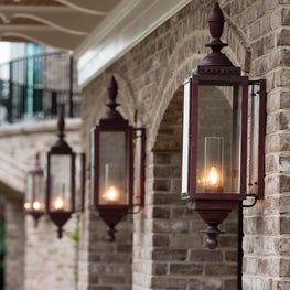 Copper Lantern Sconces Between the Brick Garage Door Arches