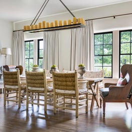 Dining room with rush chairs, antique French table, and contemporary wing chairs