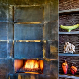 Textured metal rectangles contrast the smooth surrounds adding depth to the fireplace.