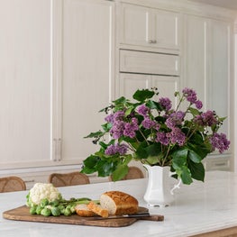 Custom millwork hides a day pantry as well as a fridge and freezer in this bespoke kitchen.