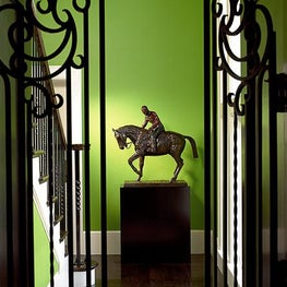 Adding a bold bright color and a strong piece of art can enhance any foyer.