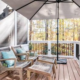 Lounge chairs with green throw accent pillow.