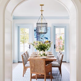 Blue and white dining room with hanging lanterns and painted trim