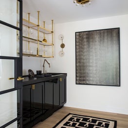 Seattle. Bar with custom shelving and cabinetry and art piece by Simon Mathers.