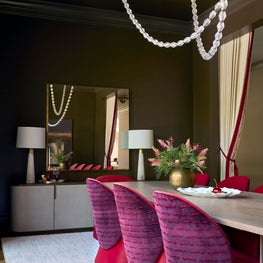 Portfolio: A dramatic dining room pairs cherry velvet dining chairs with a cerused wood table, necklace-inspired lighting, and olive-toned walls.