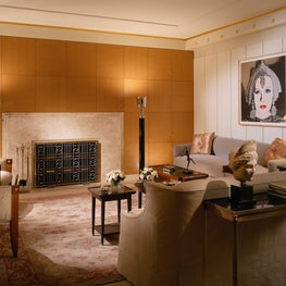  This sitting room  is accented by a fireplace with a custom marble surround . 