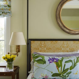 Vibrant layering of patterns in this traditional, coastal master bedroom