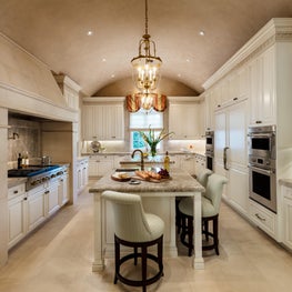 Upholstered stools surround this large kitchen island for informal comfortable meals.