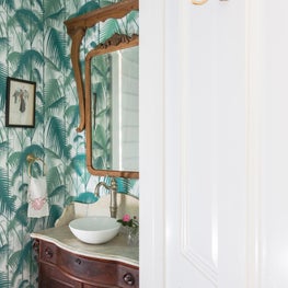 Cole and Son wallpaper covered walls inside a quaint powder room 