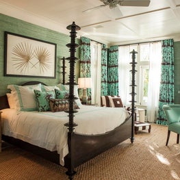 This formal four-poster bed dominates the master bedroom and looks at home on a rug of abaca grass. 