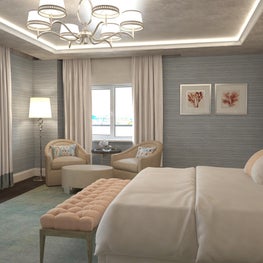 Twin upholstered midcentury beige accent chairs flank a round coffee table.